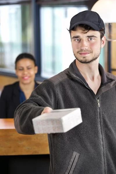 Zusteller gibt Paket im Büro ab — Stockfoto