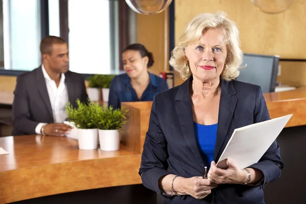 Bizneswoman gospodarstwa pliku w recepcji licznik — Zdjęcie stockowe