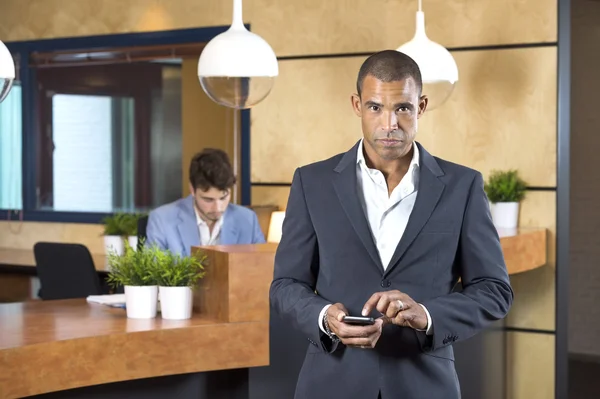 Businesswoman Holding Cellphone At Reception Desk — Stock Photo, Image