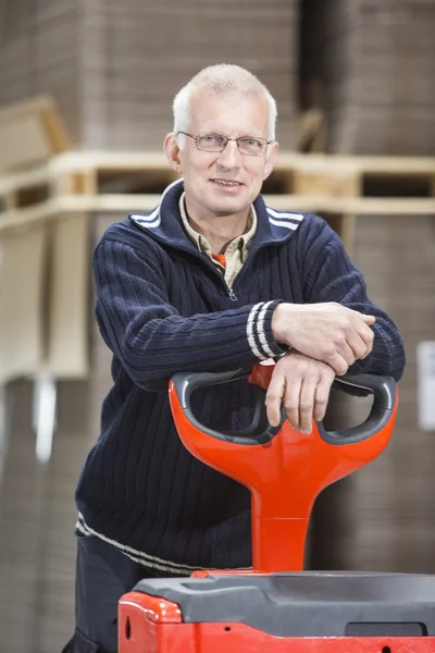 Vertrouwen werknemer leunend op Handtruck — Stockfoto