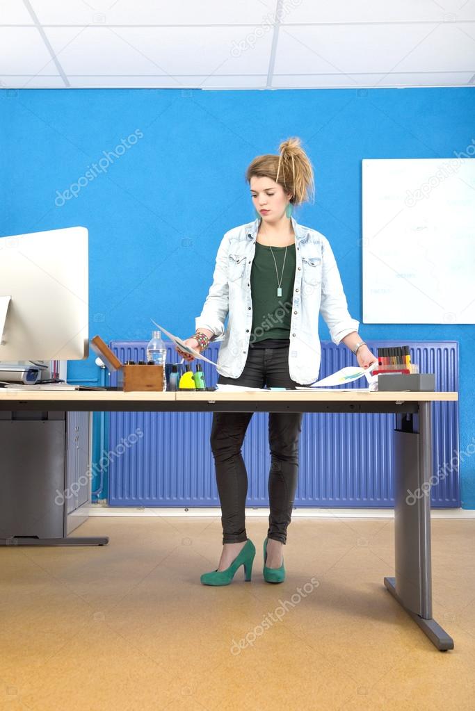 Female Designer Reading Document In Office