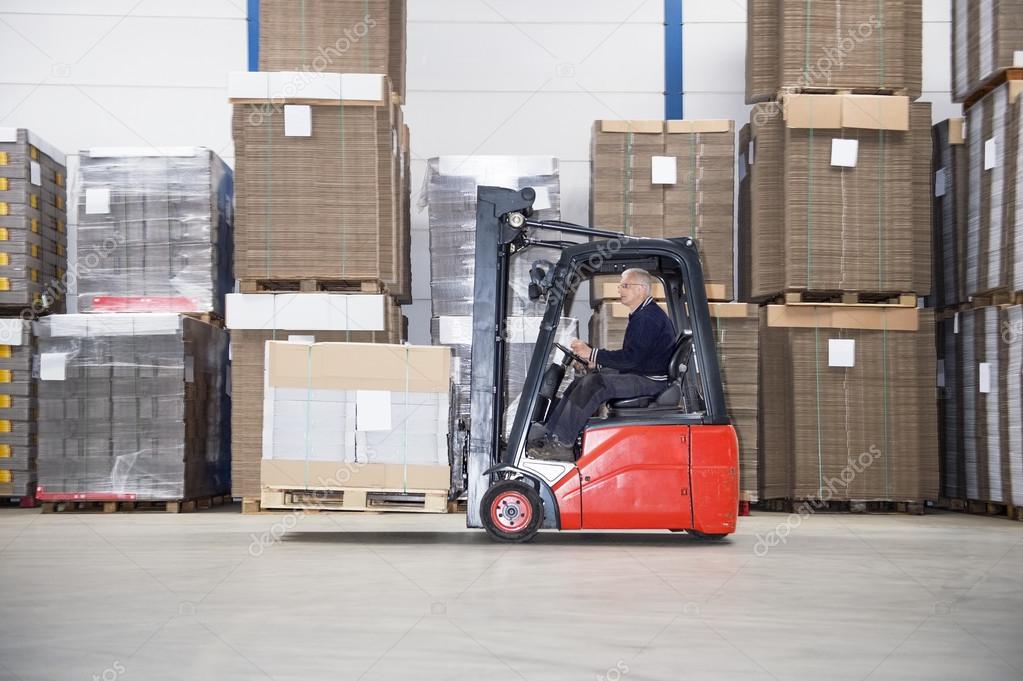 Supervisor Driving Forklift In Warehouse