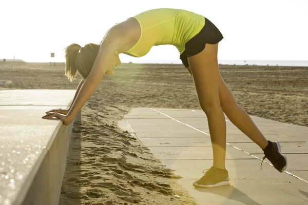 Vrouw die zich uitstrekt op een strand — Stockfoto