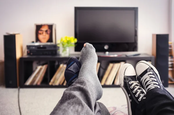 Pés de um casal no sofá — Fotografia de Stock