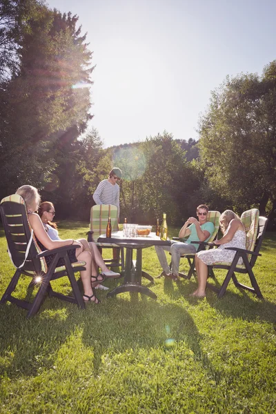 Przyjaciele wokół stołu w garden party — Zdjęcie stockowe