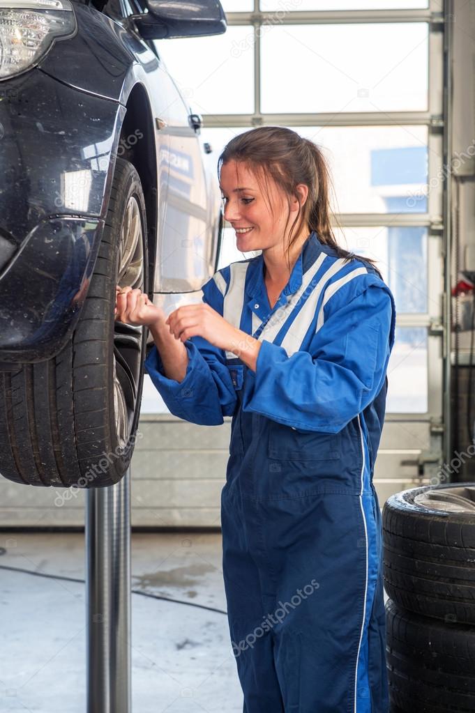female mechanic removing the bolts