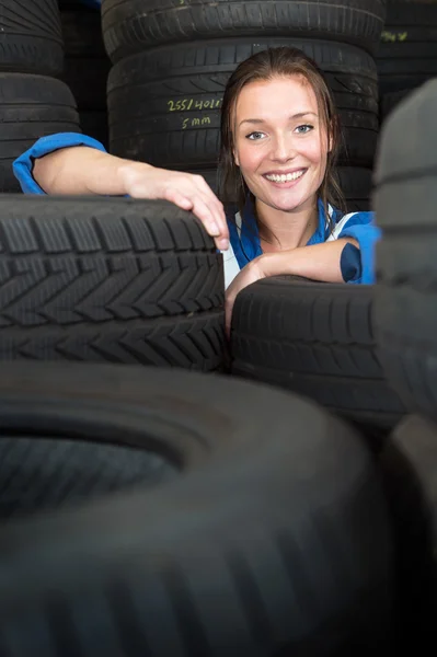 Mechanic  surrounded by stacks of tires — Stock Photo, Image