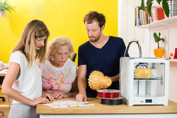 Designers discutindo enquanto segurando o produto — Fotografia de Stock