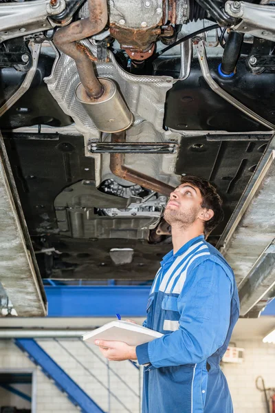 Mechaniker überprüfen Auspuffanlage — Stockfoto