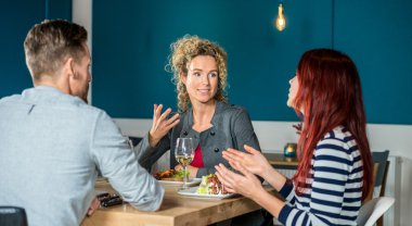 Restoranda yemek yerken konuşan arkadaşlar