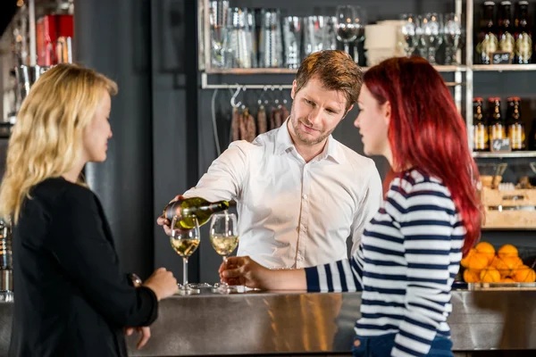 Μπάρμαν σερβίρει κρασί στους πελάτες σε Bar — Φωτογραφία Αρχείου