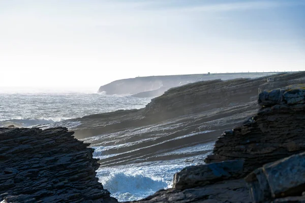 Katmanlı kireçtaşı, köpüren Atlantik sörfü, kış ışığı ve sert Wexford kıyı dokularıyla Kanca Kafa uçurumları..