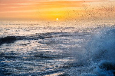 Kanca Kafa kış dalgası gün batımında, Atlantik Okyanusu 'nun ham gücünü ön plana çıkaran altın püskürtüye dönüşür..
