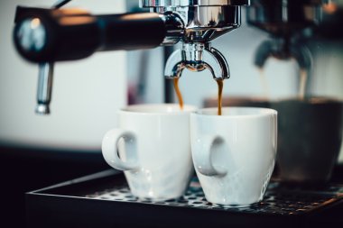 Beyaz bardaklara dökülen espresso görüntüsünü kapat