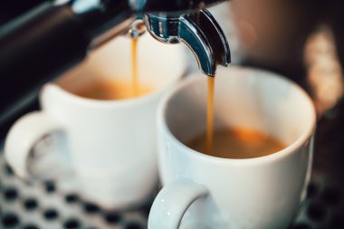 Beyaz bardaklara dökülen espresso görüntüsünü kapat