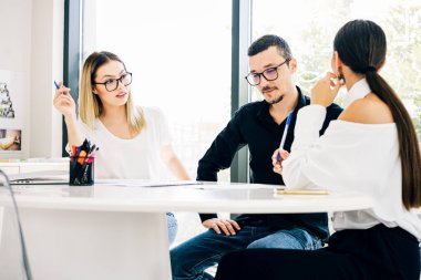 Genç profesyonel takım. Yaratıcı insanlar masada oturup ofiste beyin fırtınası yapıyorlar..