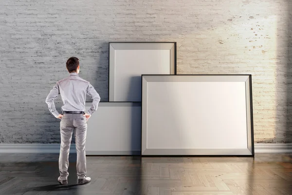 Geschäftsmann und leerer Rahmen an Vintage-Wand — Stockfoto