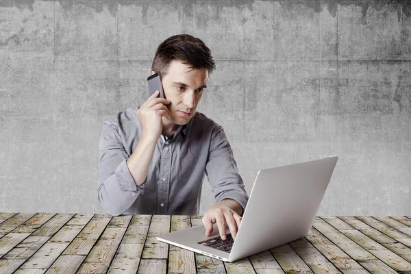 Nahaufnahme eines Multitasking-Geschäftsmannes mit Laptop und Handy — Stockfoto