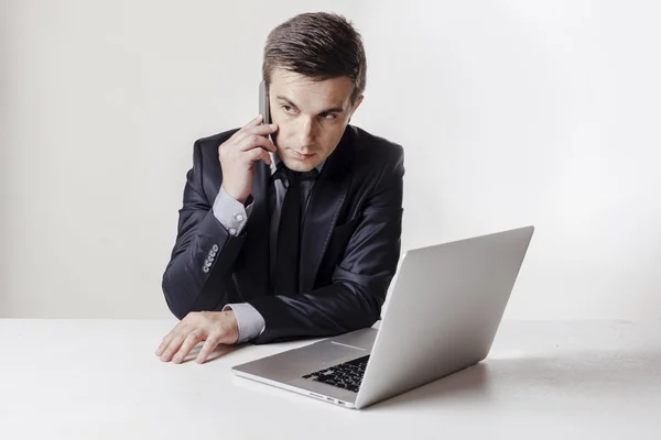 Primer plano de la imagen de hombre de negocios multitarea utilizando un ordenador portátil y teléfono móvil —  Fotos de Stock
