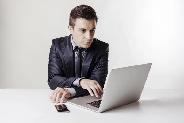 Close-up beeld van multitasking zakenman met behulp van een laptop en mobiele telefoon — Stockfoto