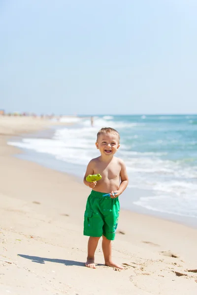 Garçon à la plage avec des bonbons Photo De Stock