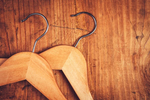 Two retro cloth hangers on rustic wooden background, top view — ストック写真