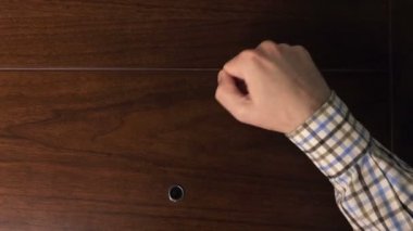 Erkek el ahşap kapısını çalıyor