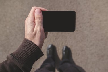 Sokakta yürürken Smartphone ekranında görünen adam