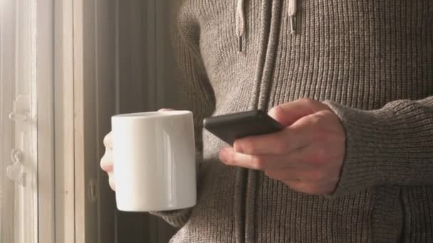 Homem bebendo café e mensagens de texto por smartphone — Vídeo de Stock