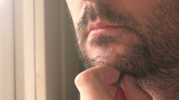 Close-up van ongeschoren mannelijk denken door het raam — Stockvideo