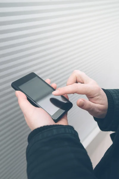 Femme utilisant un smartphone dans la rue face au mur — Photo