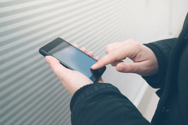 Mujer usando smartphone en la calle frente a la pared — Foto de Stock