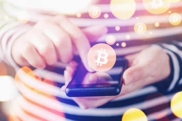 Woman paying with Bitcoins over mobile smartphone — ストック写真