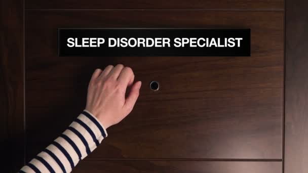 Женская рука стучится в дверь специалиста по расстройствам сна — стоковое видео