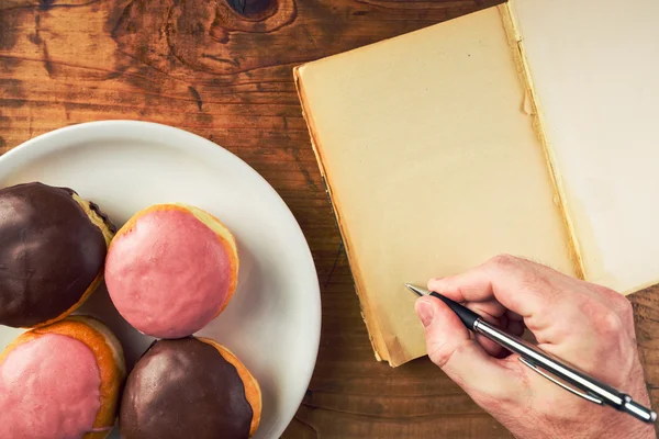 Writing recipe for homemade delicious doughnuts with sweet toppi — Stock Photo, Image