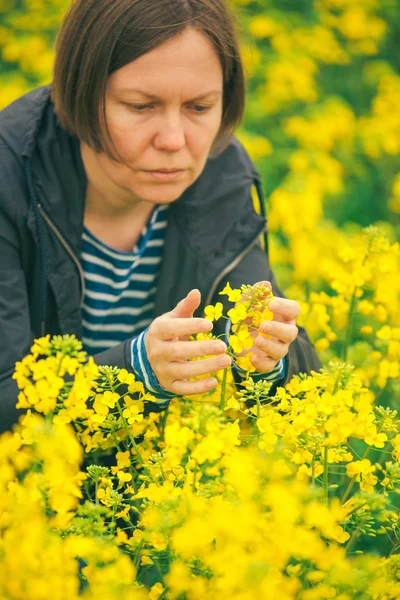 Ženská agronomka v oboru kvetoucí řepice — Stock fotografie