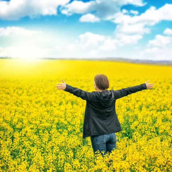 Woman agronomist standing in field of blooming cultivated rapese — Stock Photo, Image