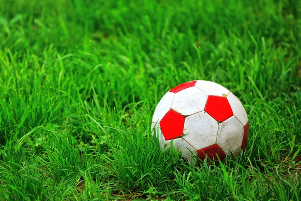 Old soccer ball in grass — Stock Photo, Image