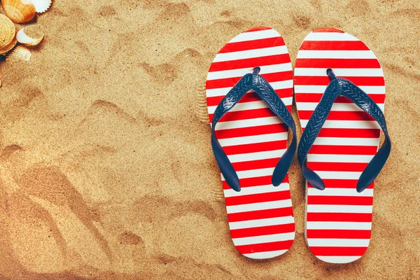Pair of thongs or flip flops on beach sand — Stock Photo, Image