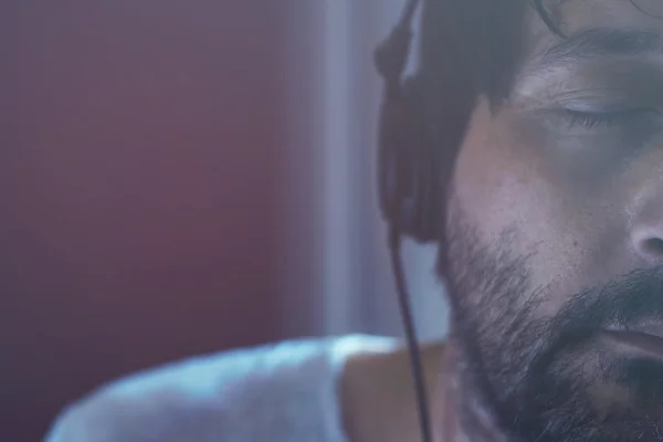 Adult man listening to music on headphones, eyes closed — Stock Photo, Image