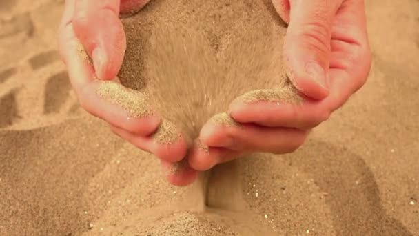 Une poignée de sable coulant à travers les doigts — Video