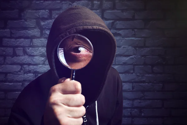 Hooded datorhackare med förstoringsglas — Stockfoto