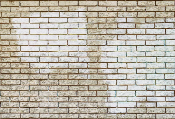 Klottersanering med vit färg över beläggning på tegelvägg — Stockfoto