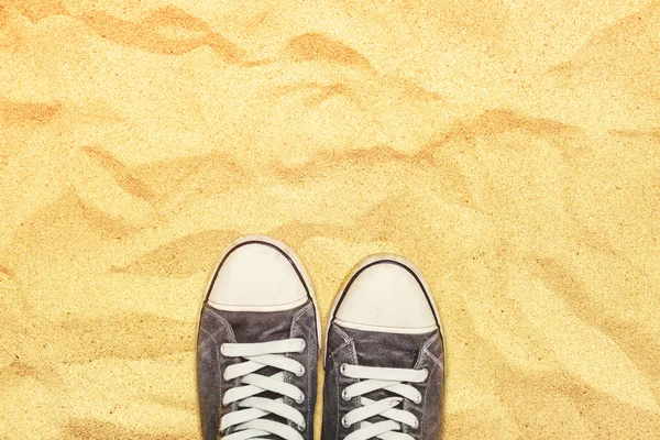 Piedi in scarpe da ginnastica in piedi sulla sabbia del deserto di guerra — Foto Stock