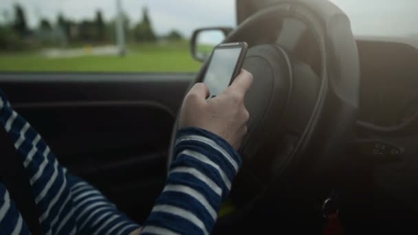 Femme voiture de conduite et SMS message sms sur smartphone 