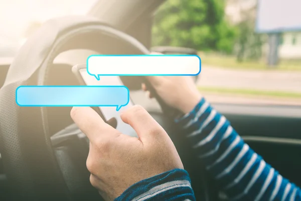 Kvinnelig kjørebil og tekstmelding på smarttelefon med talebobler – stockfoto