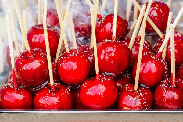 Sweet glazed red toffee candy apples on sticks — Stock Photo, Image