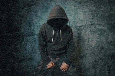 Yağmurda kapüşonlu ceket ile ürkütücü kötü suçlu kişi