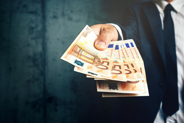Businessman from bank offering money loan in euro banknotes