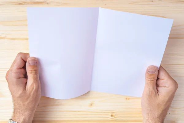Hombre sosteniendo folleto en blanco como simulacro de espacio de copia — Foto de Stock